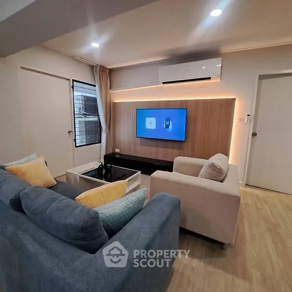 Modern living room with stylish furniture and wall-mounted TV, perfect for relaxation.