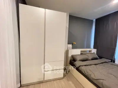 Modern bedroom with sleek white wardrobe and cozy bed in stylish apartment.