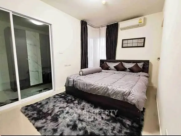 Modern bedroom with plush carpet and stylish decor in a cozy apartment.