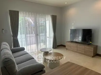 Spacious living room with modern furniture and large window for natural light.