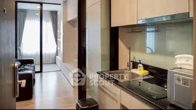 Modern apartment interior with sleek kitchen and cozy living area, featuring stylish decor and ample natural light.