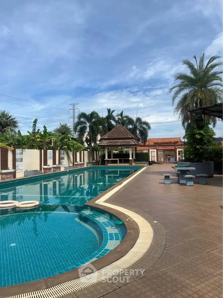 Luxurious outdoor pool area with tropical landscaping and seating, perfect for relaxation and leisure.