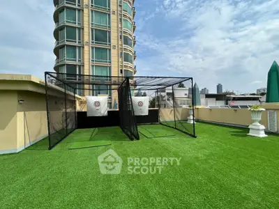 Rooftop golf practice area with artificial turf and target nets in urban setting
