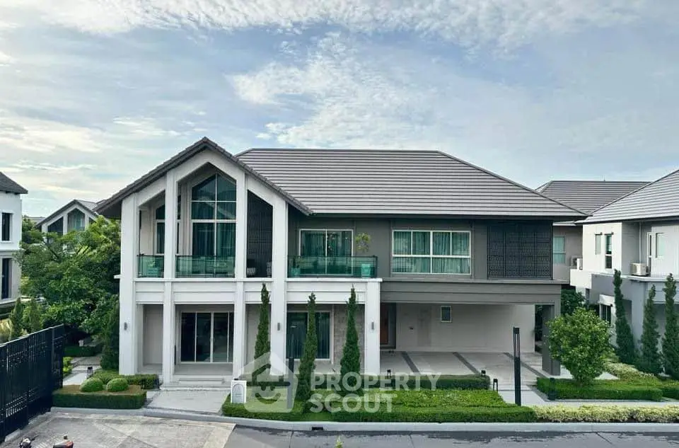 Luxurious modern house with manicured garden and spacious driveway in upscale neighborhood.