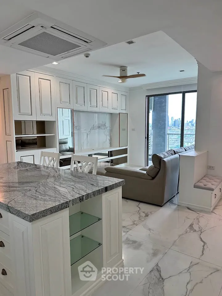 Luxurious open-plan living room with marble flooring and city view, featuring elegant kitchen island and modern furnishings.