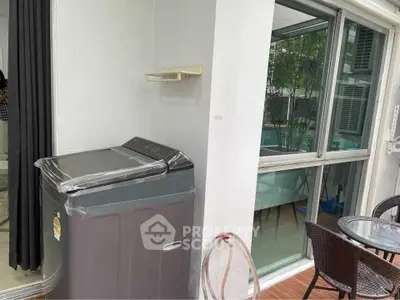 Modern apartment balcony with washing machine and pool view.