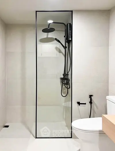 Modern minimalist bathroom with sleek shower and toilet design.