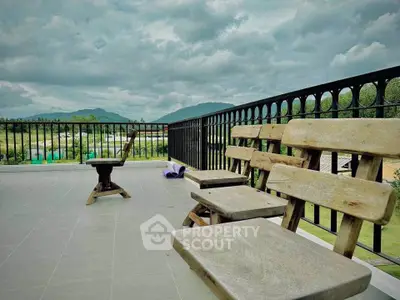 Spacious balcony with scenic mountain views and rustic wooden seating, perfect for relaxation.