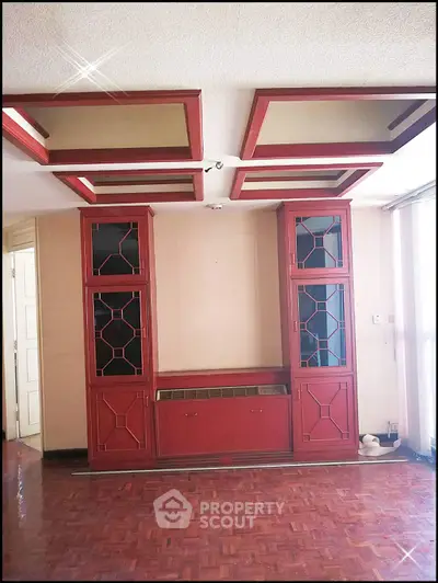 Elegant living room with unique red cabinetry and parquet flooring