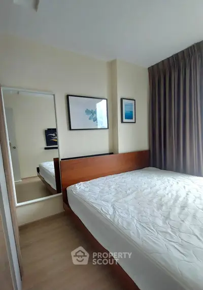 Modern bedroom with wooden flooring, large window, and stylish decor in a cozy apartment.