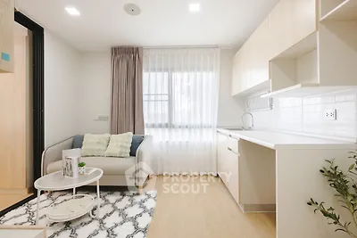 Modern living room with cozy sofa and stylish kitchen in open layout