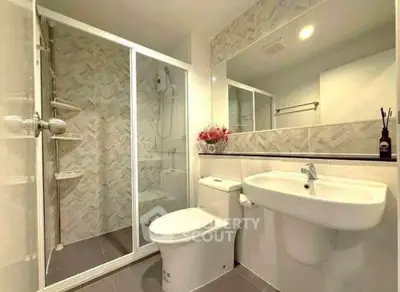 Modern bathroom with glass shower, sleek fixtures, and elegant tile design.