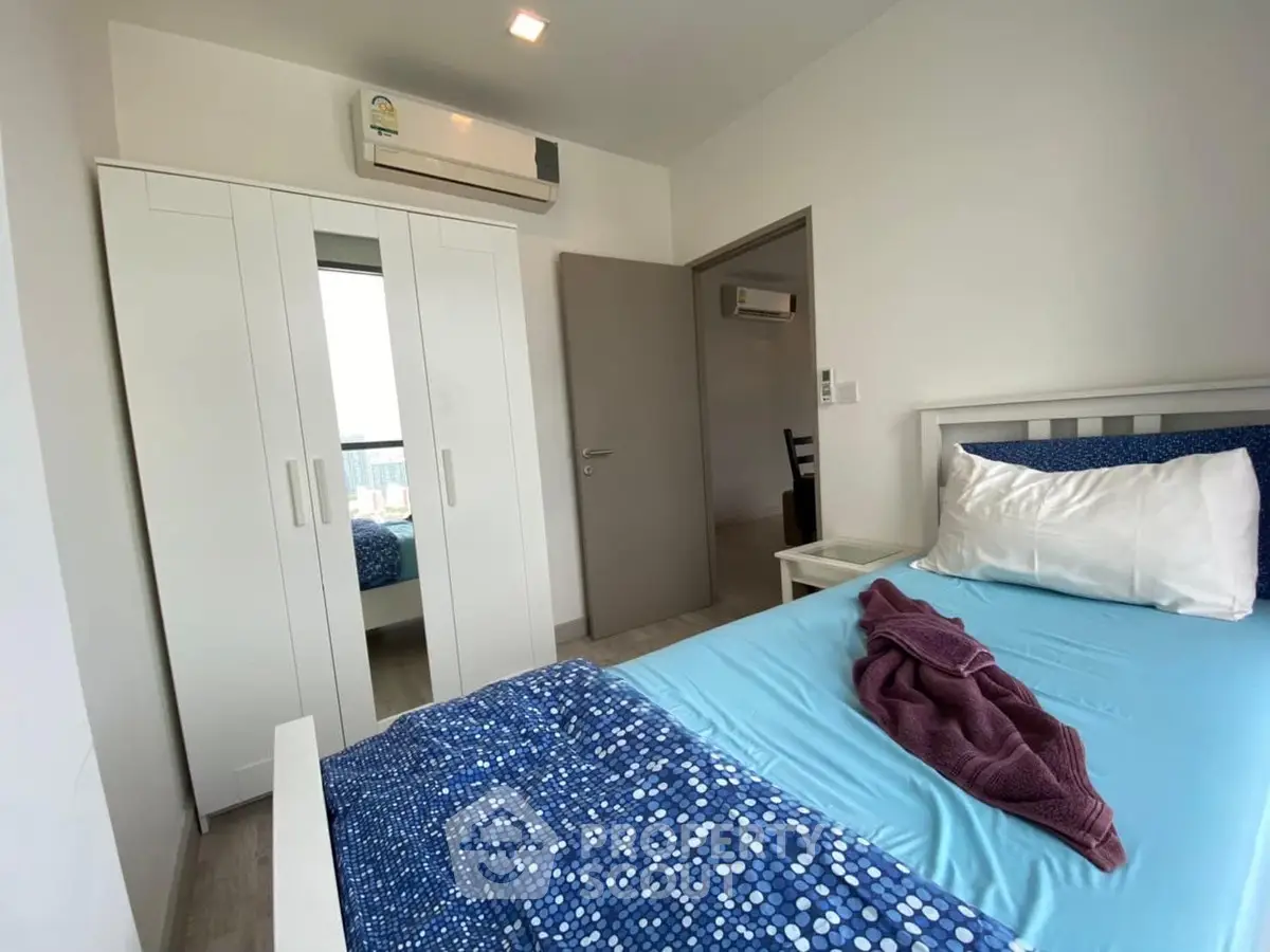 Cozy bedroom with modern decor and air conditioning in a stylish apartment.