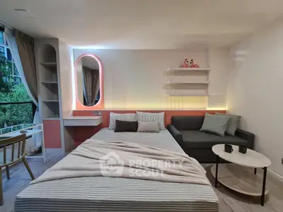 Modern studio apartment with stylish decor and cozy furnishings, featuring a comfortable bed and a chic sofa.