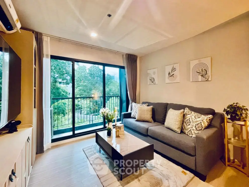 Stylish living room with modern decor and large windows overlooking lush greenery.