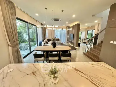 Luxurious open-plan living room with elegant marble table and garden view, perfect for modern family living.