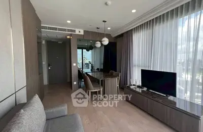Modern living room with elegant furniture and city view through large windows.