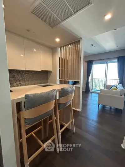 Modern open kitchen with stylish bar seating and cozy living area