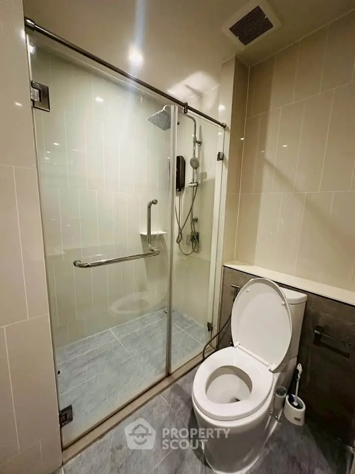 Modern bathroom with glass shower enclosure and sleek toilet design.