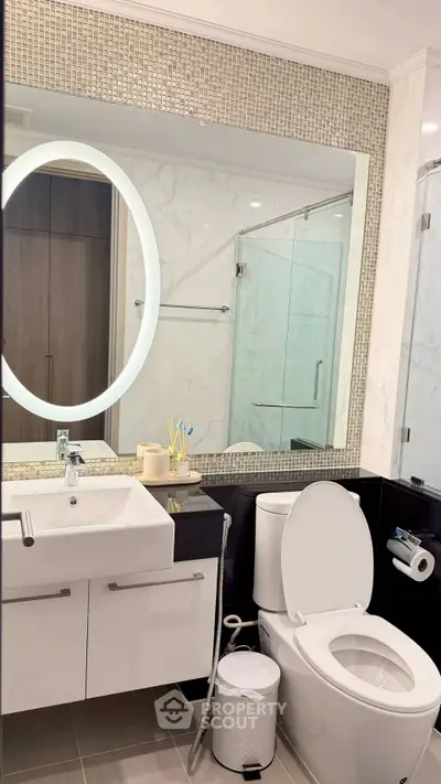 Modern bathroom with elegant fixtures and large mirror in luxury apartment.