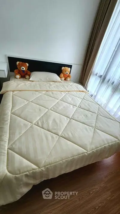 Cozy bedroom with plush bedding and natural light from large window