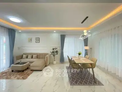Spacious modern living and dining area with elegant lighting and cozy seating.