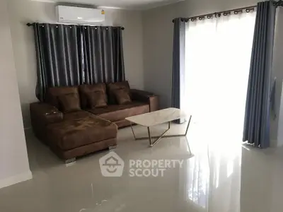 Modern living room with brown sofa, marble coffee table, and elegant curtains.