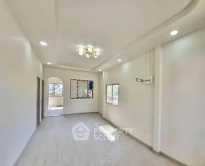 Spacious and bright living room with modern ceiling lights and large windows.