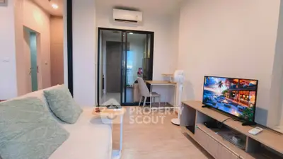 Modern living room with cozy sofa, TV, and study area in a stylish apartment.