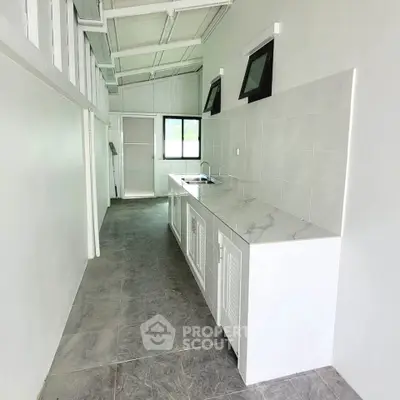 Sleek modern kitchen with marble countertops and ample natural light, perfect for culinary enthusiasts.