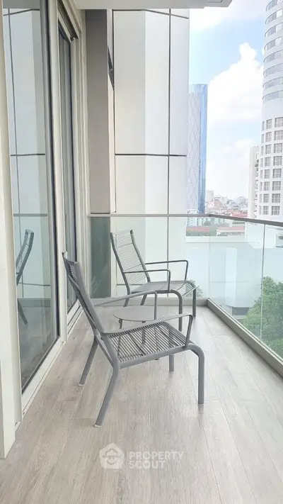 Modern balcony with city view and stylish seating in high-rise building.