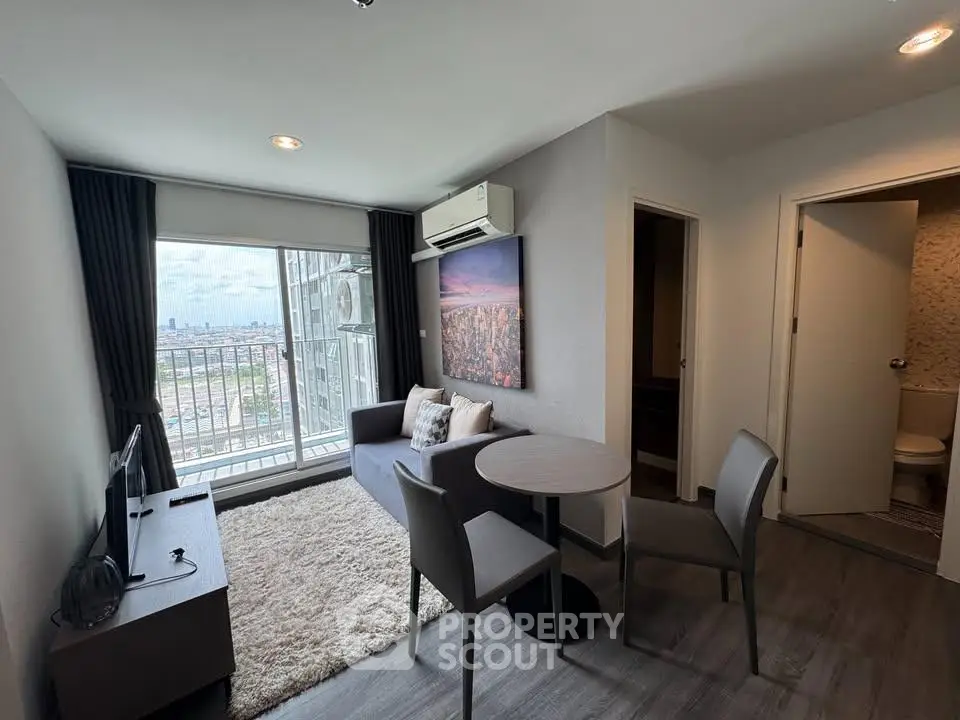 Modern living room with city view, featuring cozy seating and stylish decor in a high-rise apartment.
