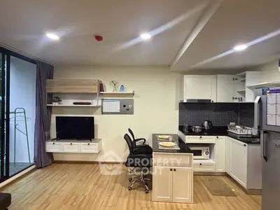 Modern open-layout kitchen and living area with sleek design and balcony access.