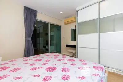 Modern bedroom with floral bedding and sliding wardrobe doors