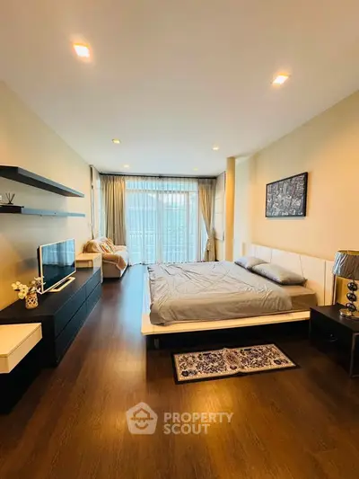 Spacious modern bedroom with elegant decor and large windows offering natural light.