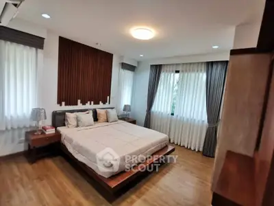 Spacious modern bedroom with elegant wooden flooring and stylish decor