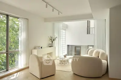 Elegant modern living room with plush seating and large windows offering natural light.