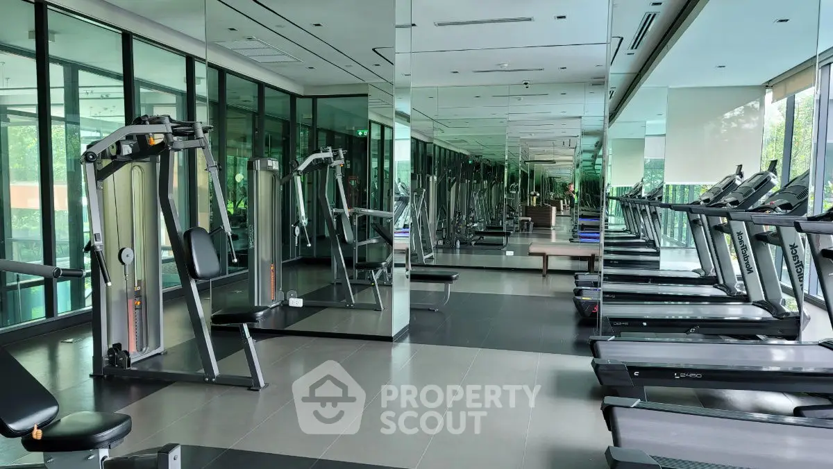 Spacious modern gym with state-of-the-art equipment and floor-to-ceiling windows.