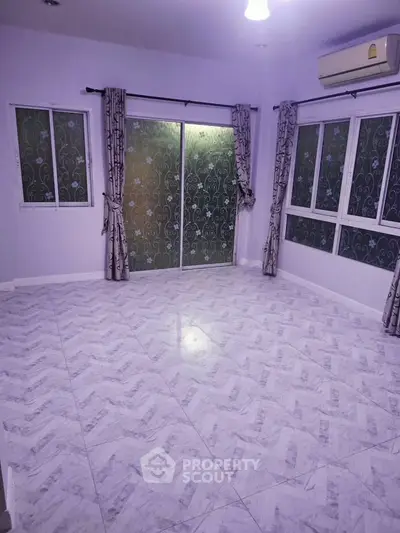 Spacious empty room with elegant tile flooring and large windows