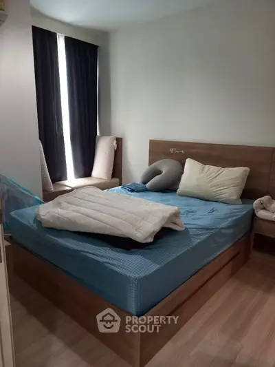 Cozy bedroom with a large bed, wooden headboard, and elegant dark curtains, offering a tranquil retreat in a modern home.