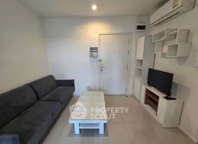 Modern living room with sleek furniture and wall-mounted TV in a cozy apartment.