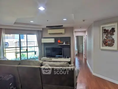 Spacious living room with modern decor and large windows offering city views.