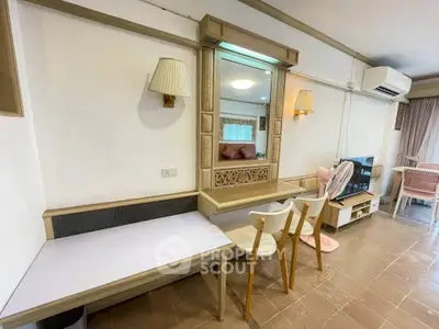 Charming living room with modern decor and ample natural light, featuring stylish furniture and air conditioning.