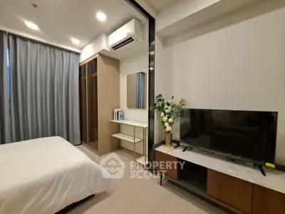 Modern bedroom with sleek design, featuring a TV, air conditioning, and elegant decor.