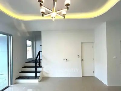 Modern interior with elegant lighting and staircase in a spacious living area.