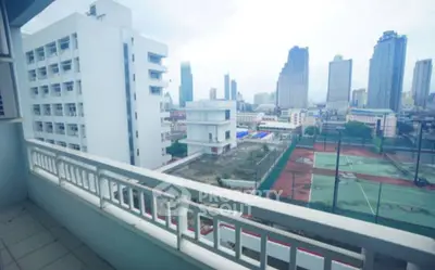 Spacious balcony with cityscape view and tennis courts, ideal for urban living.