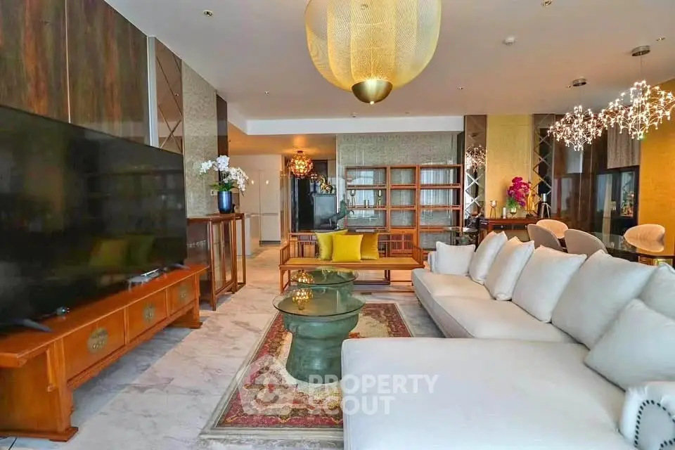 Luxurious living room with elegant decor, large TV, and stylish lighting in a modern apartment.