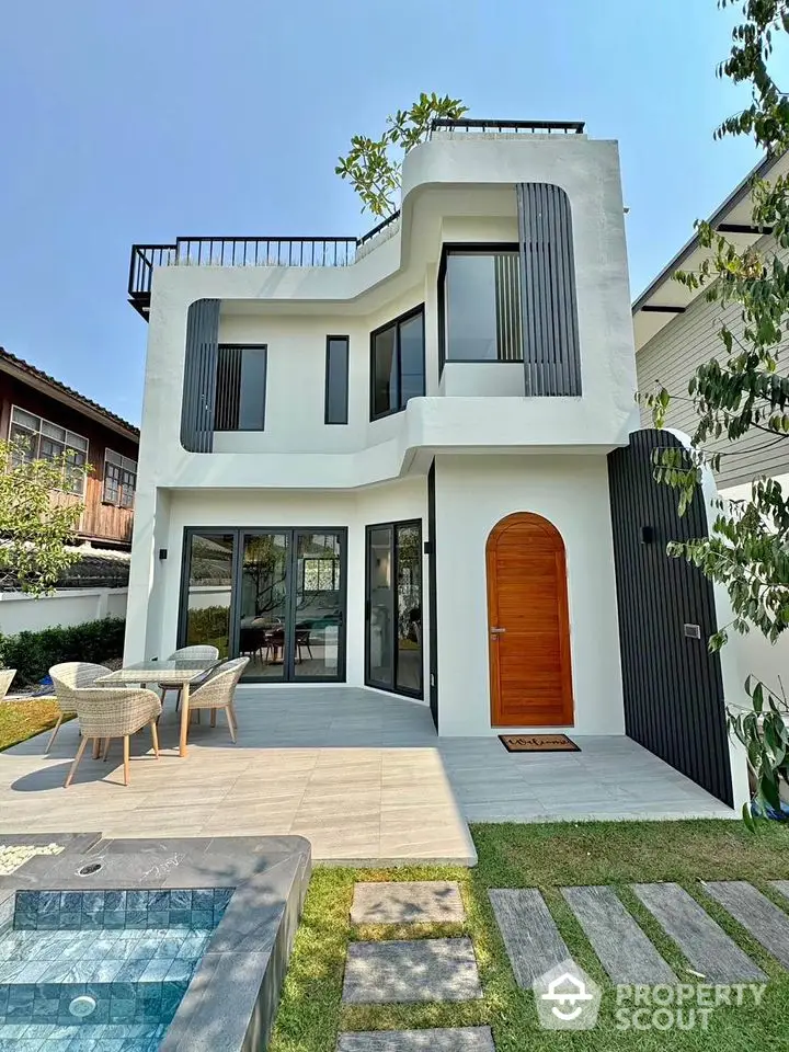 Modern two-story house with unique architecture and outdoor seating area