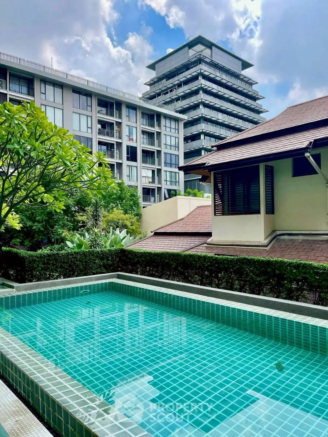 Luxurious residential complex with a serene private pool and lush greenery, perfect for urban living.