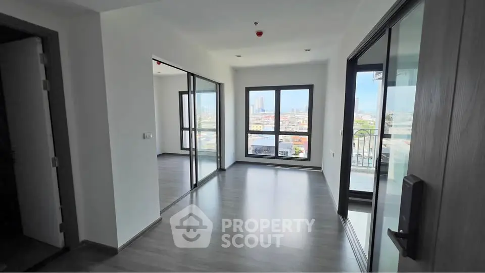 Spacious modern apartment with large windows and city view, perfect for urban living.